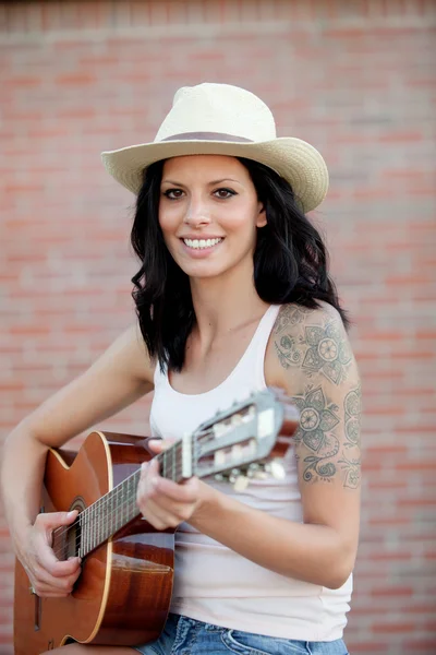 Brünette hübsche Frau spielt eine Gitarre — Stockfoto