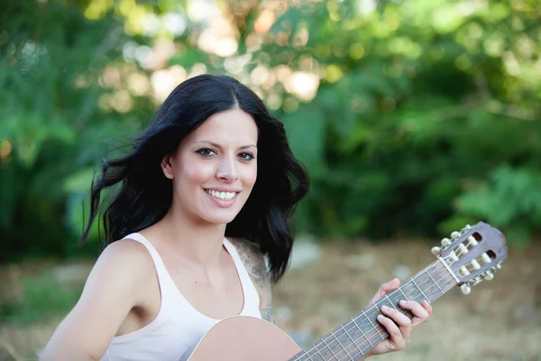 Brunett vacker kvinna med en gitarr — Stockfoto