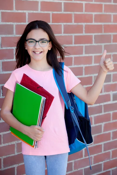 Menina pré-adolescente com mochila e livros — Fotografia de Stock