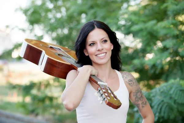 Brunette pretty woman with a guitar — Stock Photo, Image