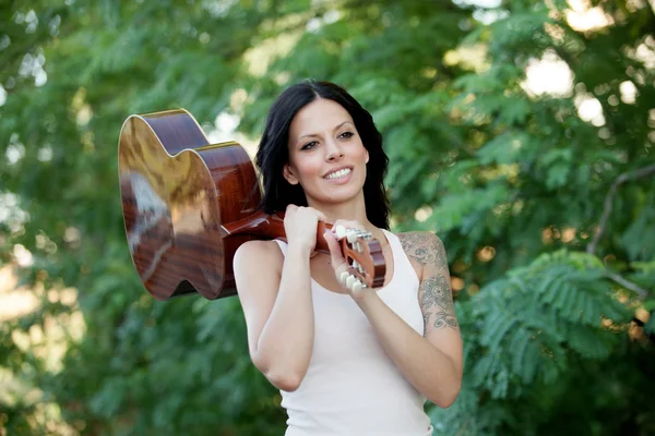 Brunette pretty woman with a guitar — Stock Photo, Image