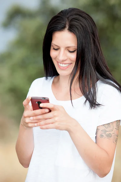 Розслаблена брюнетка жінка дивиться на свій мобільний — стокове фото