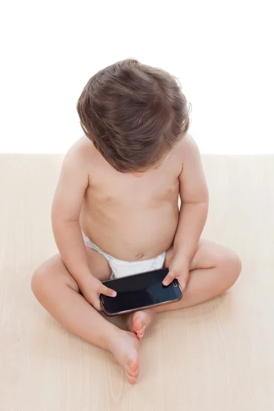 Um ano de idade menino brincando com um celular — Fotografia de Stock