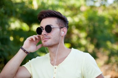 parkta müzik dinleme güneş gözlüklü adam