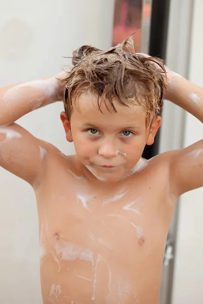 Grappige jongen douchen in de tuin — Stockfoto