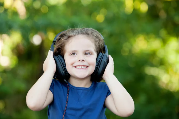 Kleines Mädchen mit Kopfhörern draußen — Stockfoto