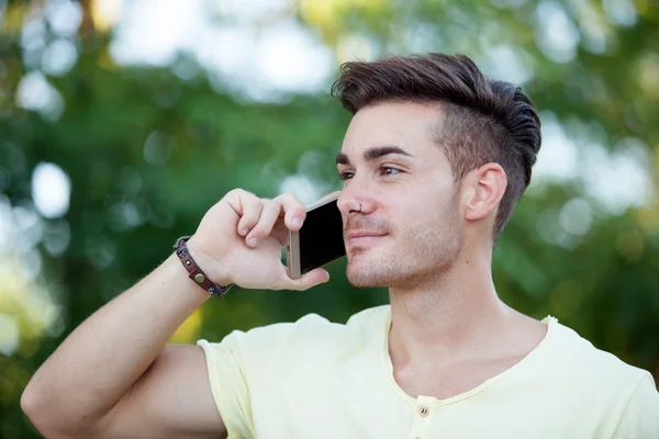 Homme attrayant avec téléphone portable dans le parc — Photo