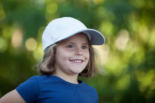 Menina bonito vestindo um boné no parque — Fotografia de Stock