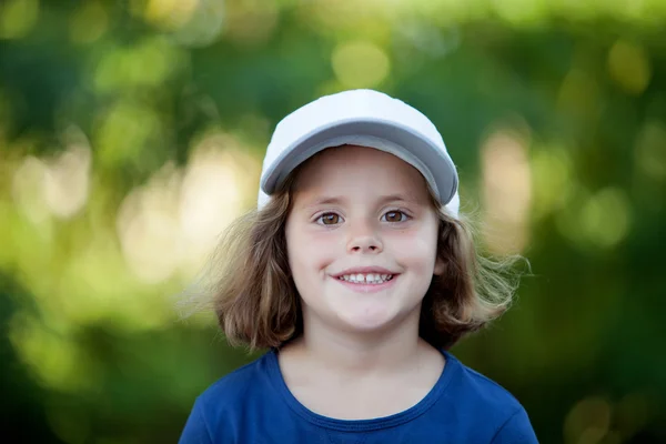 Menina bonito vestindo um boné no parque — Fotografia de Stock