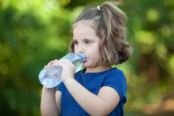 Schattig klein meisje met fles water — Stockfoto