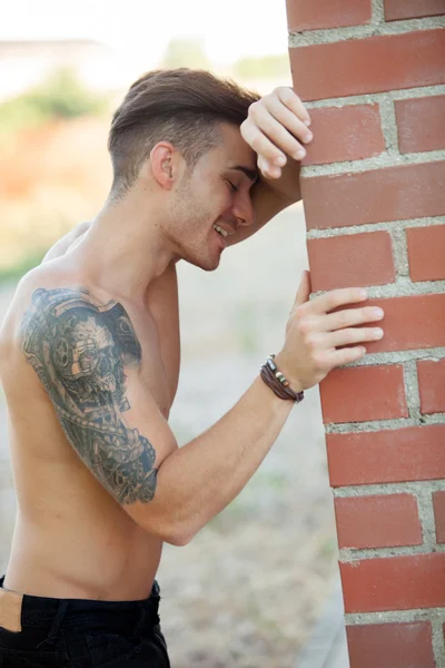 In forma uomo atletico appoggiato a un muro di mattoni — Foto Stock
