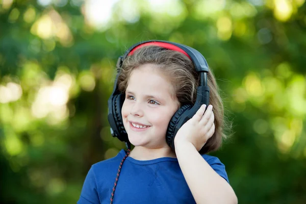 Niña con auriculares afuera —  Fotos de Stock