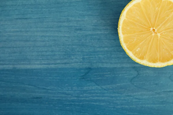Halbe Zitrone auf blauem Holz — Stockfoto