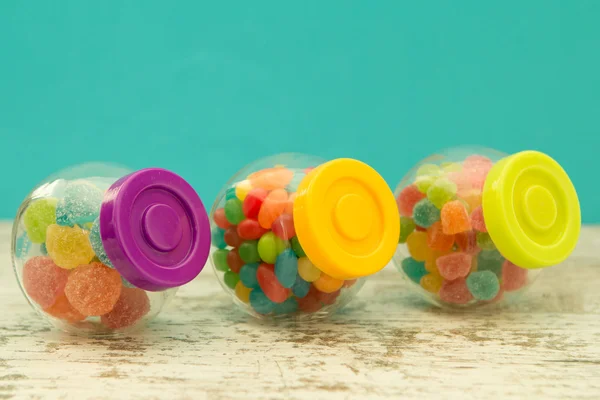 Drie glazen containers vol jellybeans met blauwe achtergrond — Stockfoto