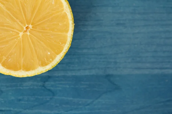 Половина лимона на синьому дереві — стокове фото