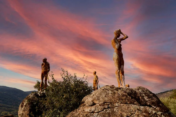 日没時に大きな岩の上に人々の石の像 — ストック写真