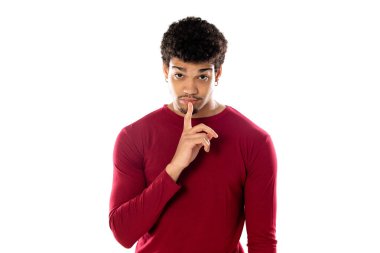 Beyaz arka planda izole edilmiş bordo bir tişört giyen Afro saçlı tatlı Afro-Amerikalı bir adam.