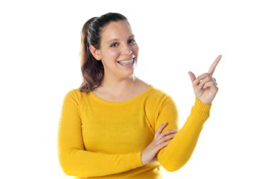 Diş teli takan, sarı bir forma giyen, beyaz bir arka planda izole edilmiş yetişkin bir kadın.
