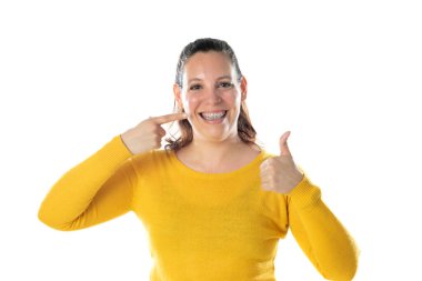 Diş teli takan, sarı bir forma giyen, beyaz bir arka planda izole edilmiş yetişkin bir kadın.