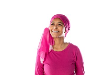 Beyaz bir arka planda pembe başörtüsü takan genç, güzel Afrikalı kadın.