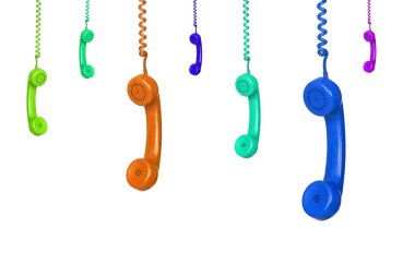 Beyaz arka planda izole edilmiş pek çok renkli eski telefon asılı.