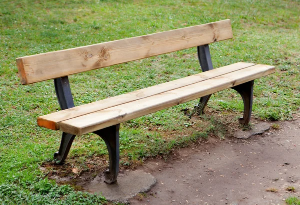 Деревянная скамейка в парке на траве — стоковое фото