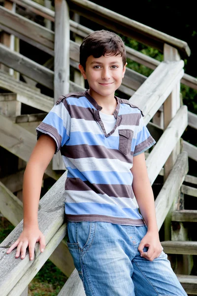 Trevlig preteen pojke ler i trätrappor — Stockfoto