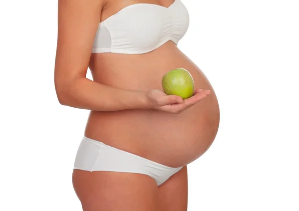 Body pregnant in underwear with a green apple — Stock Photo, Image