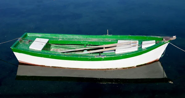Barco solitario verde y blanco en un mar tranquilo Fotos De Stock Sin Royalties Gratis