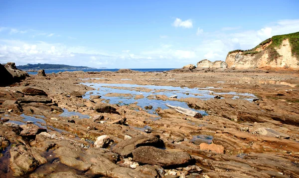 Pozzanghere d'acqua sulla roccia con bassa marea — Foto Stock
