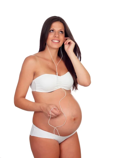 Красивая беременная слушает музыку — стоковое фото