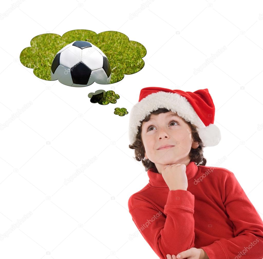 Child in Chistmas hat thinking about a soccer ball