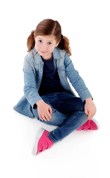 Sevimli küçük kız kot gömlek ile katta oturan — Stok fotoğraf