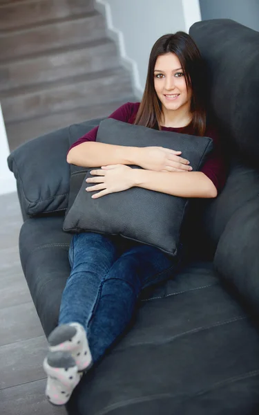 Genç kadın evde onun kanepede rahatlatıcı — Stok fotoğraf