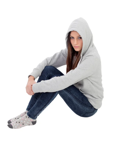 Angry hooded girl with grey sweatshirt sitting on the floor Stock Photo