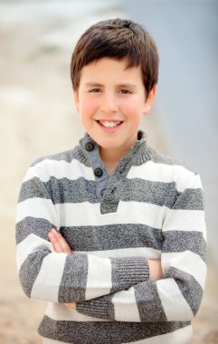 On üç çizgili kazaklı genç çocuk gülümseyen