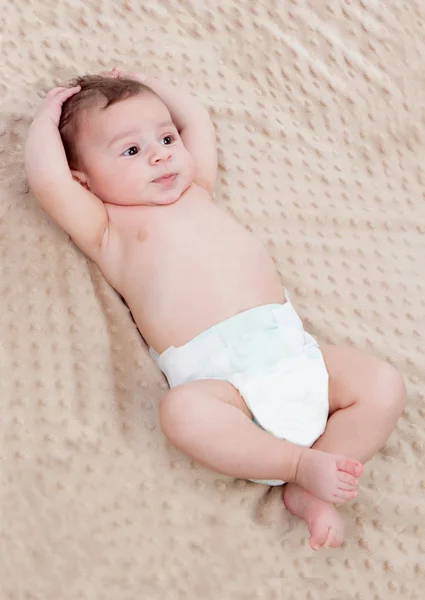 Niedliches Baby auf brauner Decke überrascht — Stockfoto