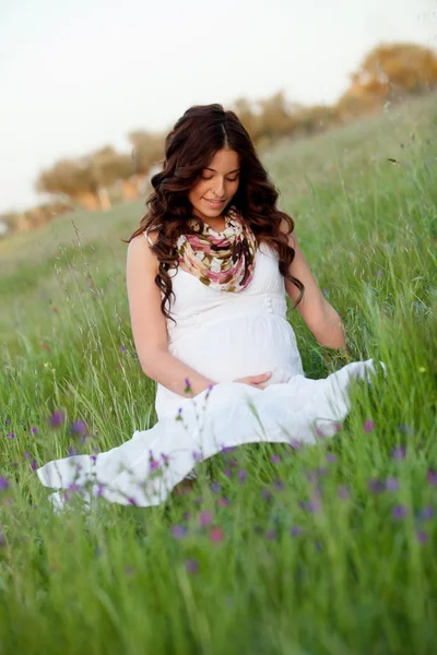 Relaxado mulher grávida sentado na grama — Fotografia de Stock