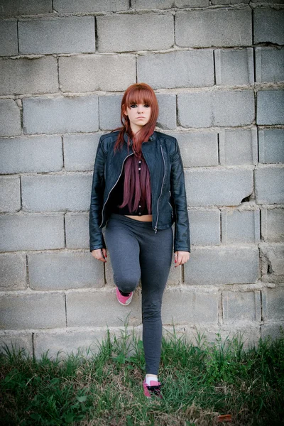 Adolescente rebelle aux cheveux roux appuyée sur un mur — Photo