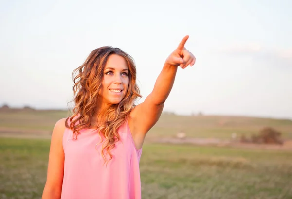 Woman indicating something in the countryside — Stock Photo, Image