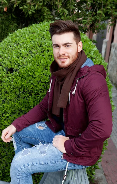 Guay chico guapo con barba sentado en un banco — Foto de Stock