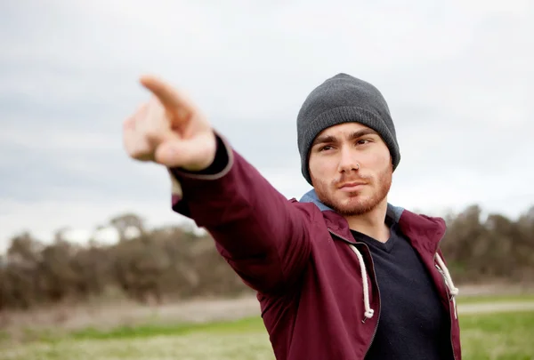 Cool handsome guy at outside pointing something — Stock Photo, Image