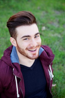 Sakallı yakışıklı adam gülümsüyor. 