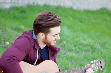 Gitar çalmak sakallı serin yakışıklı adam 