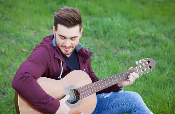 Cool handsome guy playing guitar at outside — Stock Photo, Image