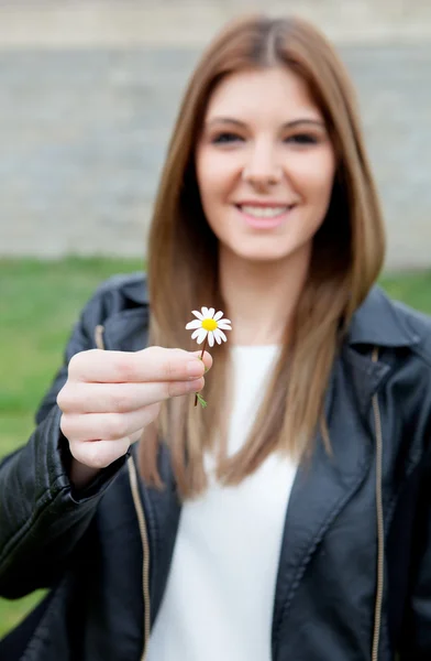 Ziemlich cooles Mädchen bietet eine schöne Blume — Stockfoto