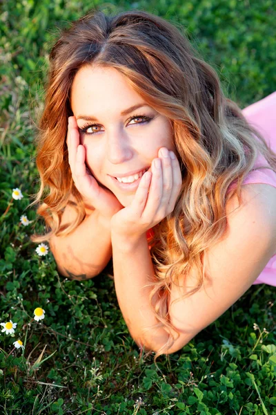 Mooie blonde vrouw in een veld vol met bloemen — Stockfoto