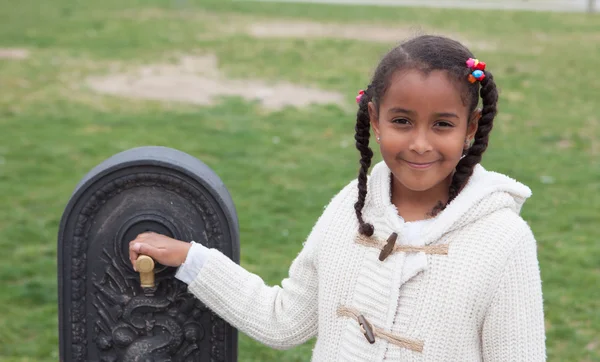 Pretty african child by a fountain — Stock Photo, Image