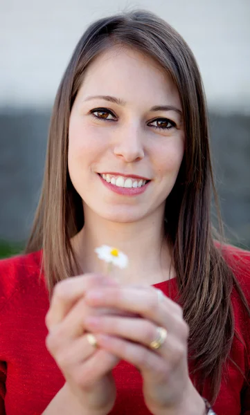 Linda chica sonriente sosteniendo una margarita — Foto de Stock