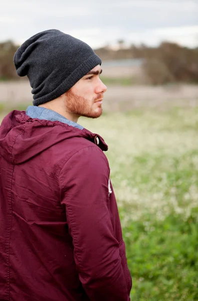 Handsome guy with beard in the field thinking — Stock Photo, Image